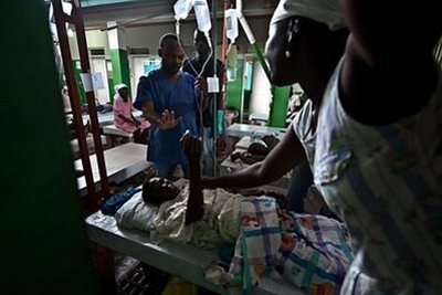 Um enfermeiro trata uma vítima de cólera no Hospital Charles Colimon em Petite Rivière, no Haiti