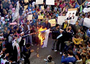 Manifestantes sírios queimam uma imagem do presidente Bashar al-Assad