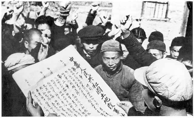 Um homem lê em voz alta a lei da reforma agrária aprovada pelo novo governo socialista, 1950