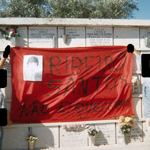 Camaradas seguram uma faixa de pano frente à campa de Ribeiro Santos